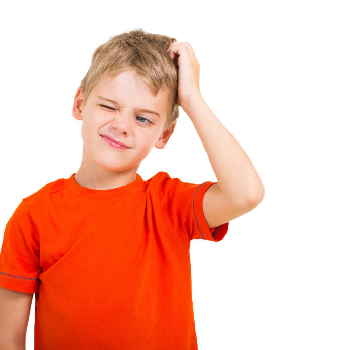 young boy scratching his head isolated on white